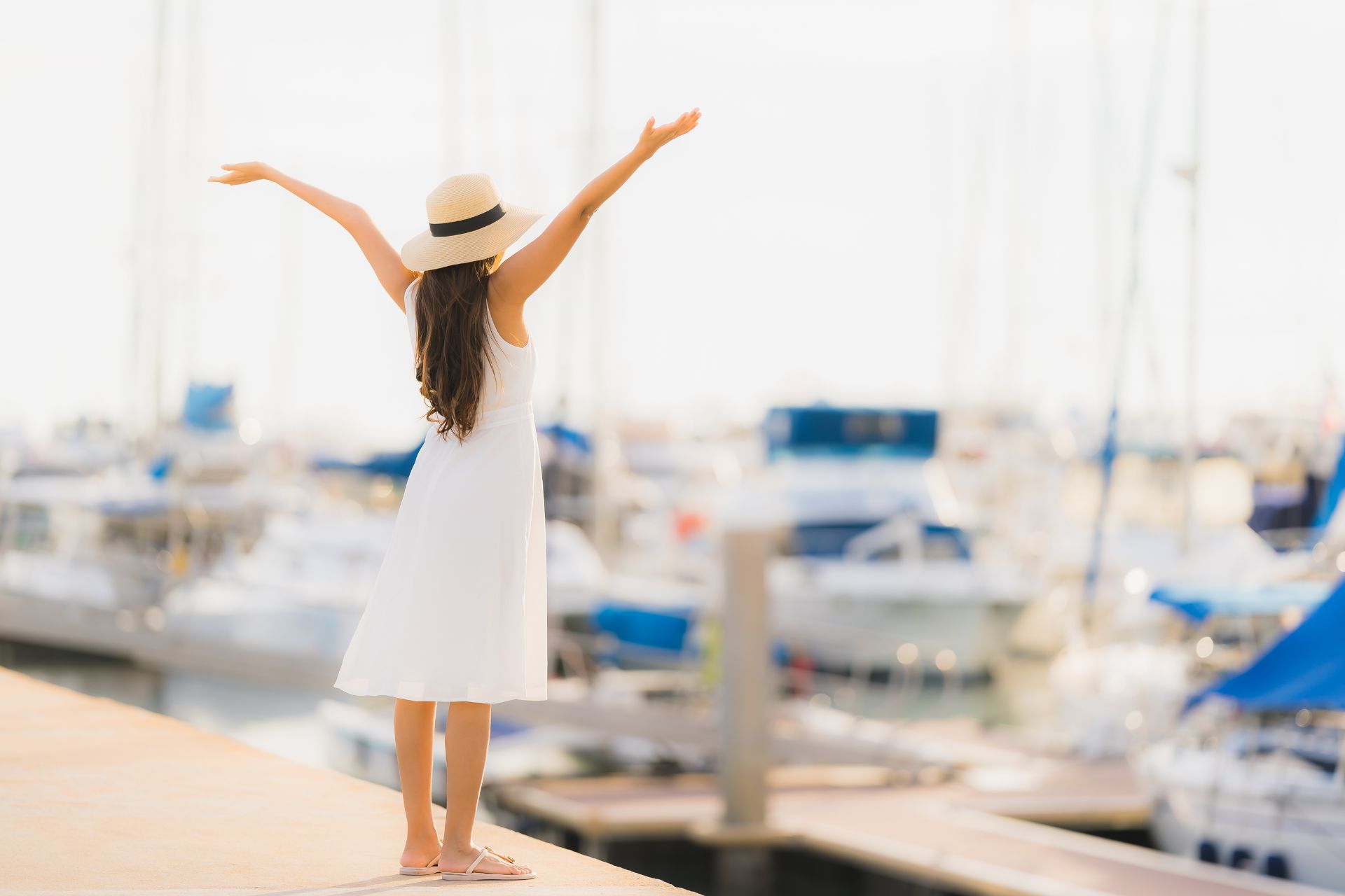 Happy woman in a marina with yachts.