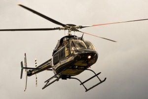 Black helicopter flying in the sky.