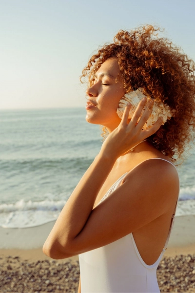 Woman at the beach with a seashell.