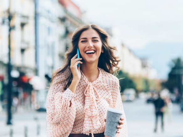 Woman with phone and coffee.