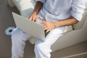 Business man with laptop on a yacht.