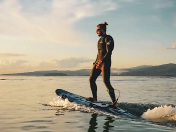 Man on electric surfboard on the sea.