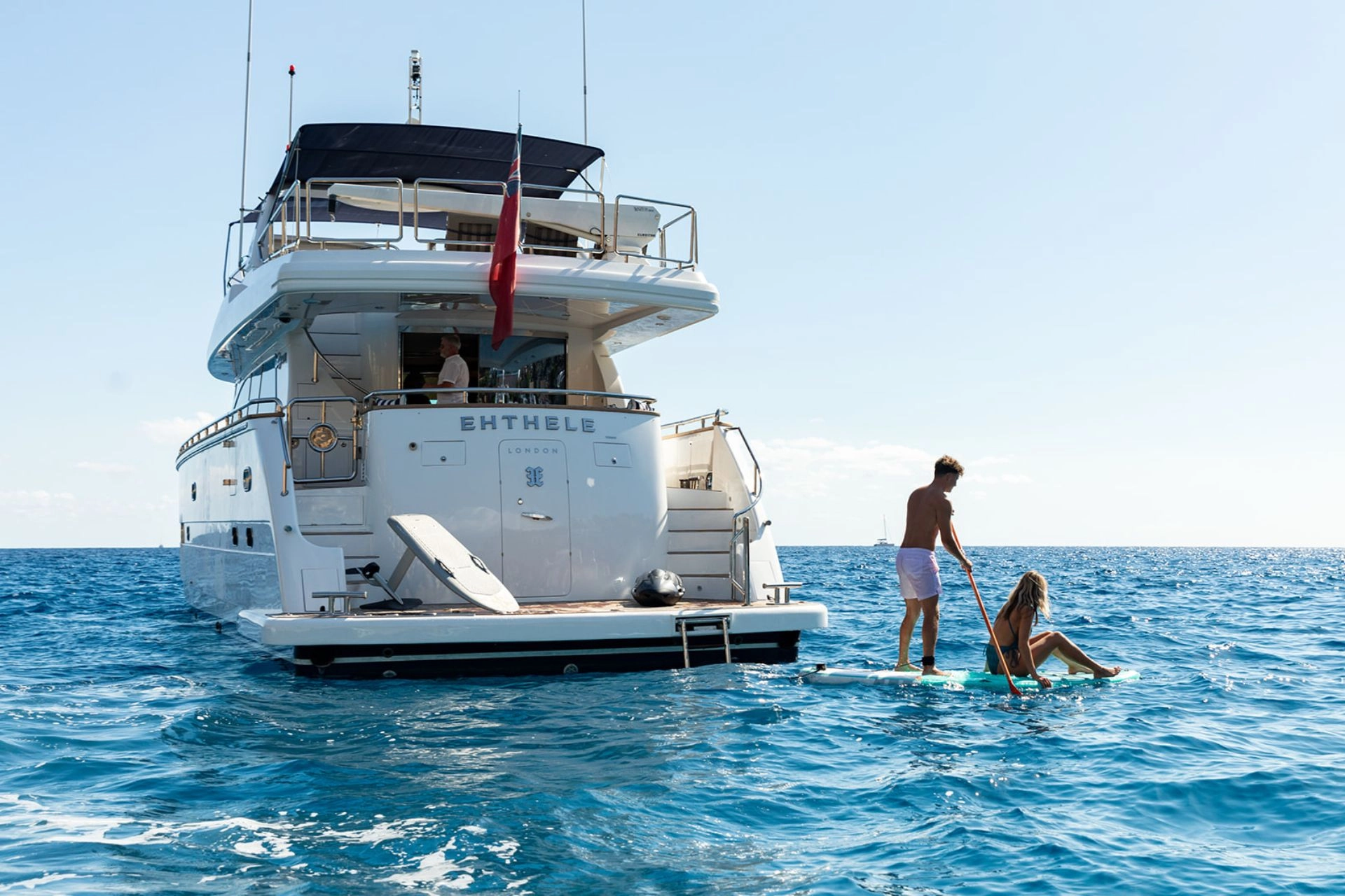 Motor yacht Elegance 78 Ethele with couple on a paddle board in the Mediterranean.