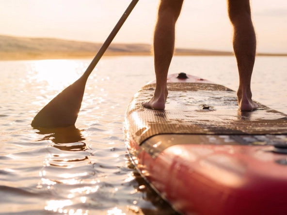 Man standing on stand up paddle board on the sea.