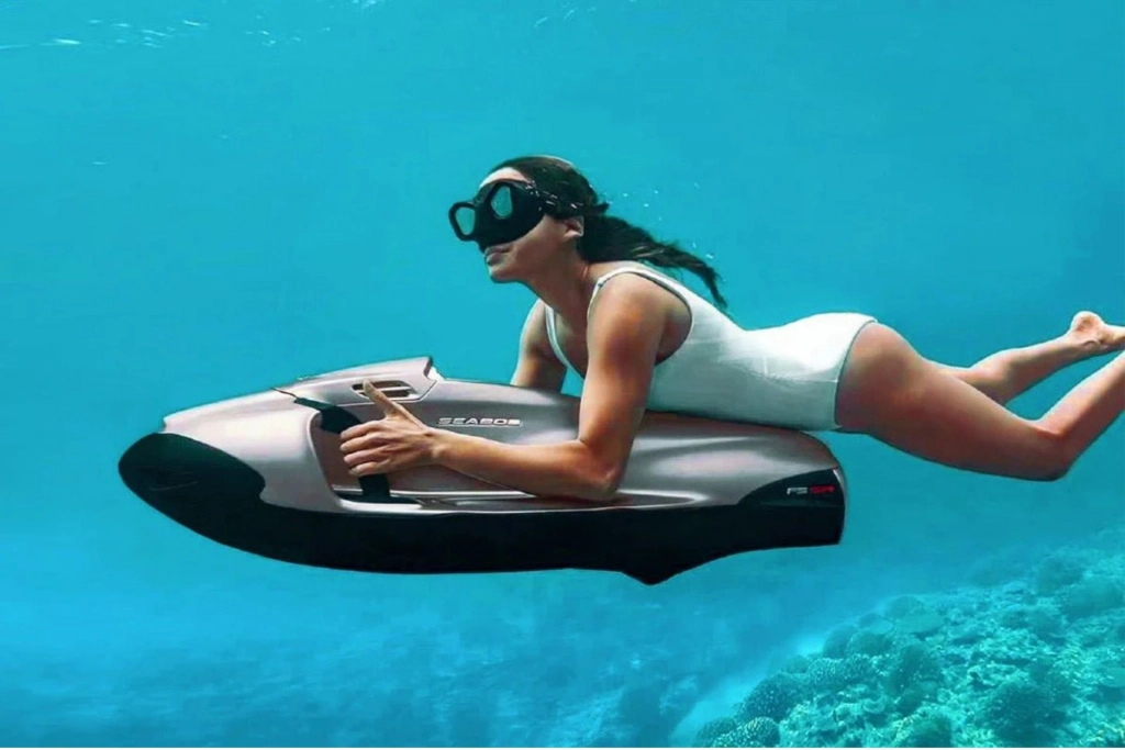 Woman riding a Seabob underwater.
