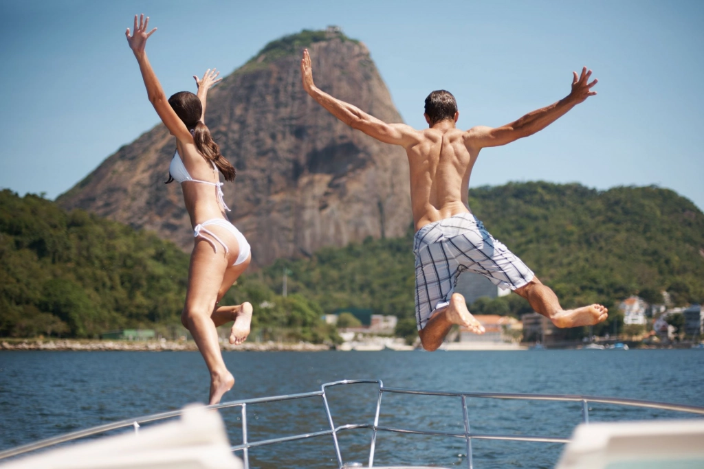 Couple jumping from a yacht.