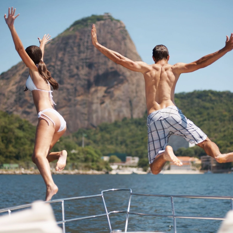 Couple jumping from a yacht.