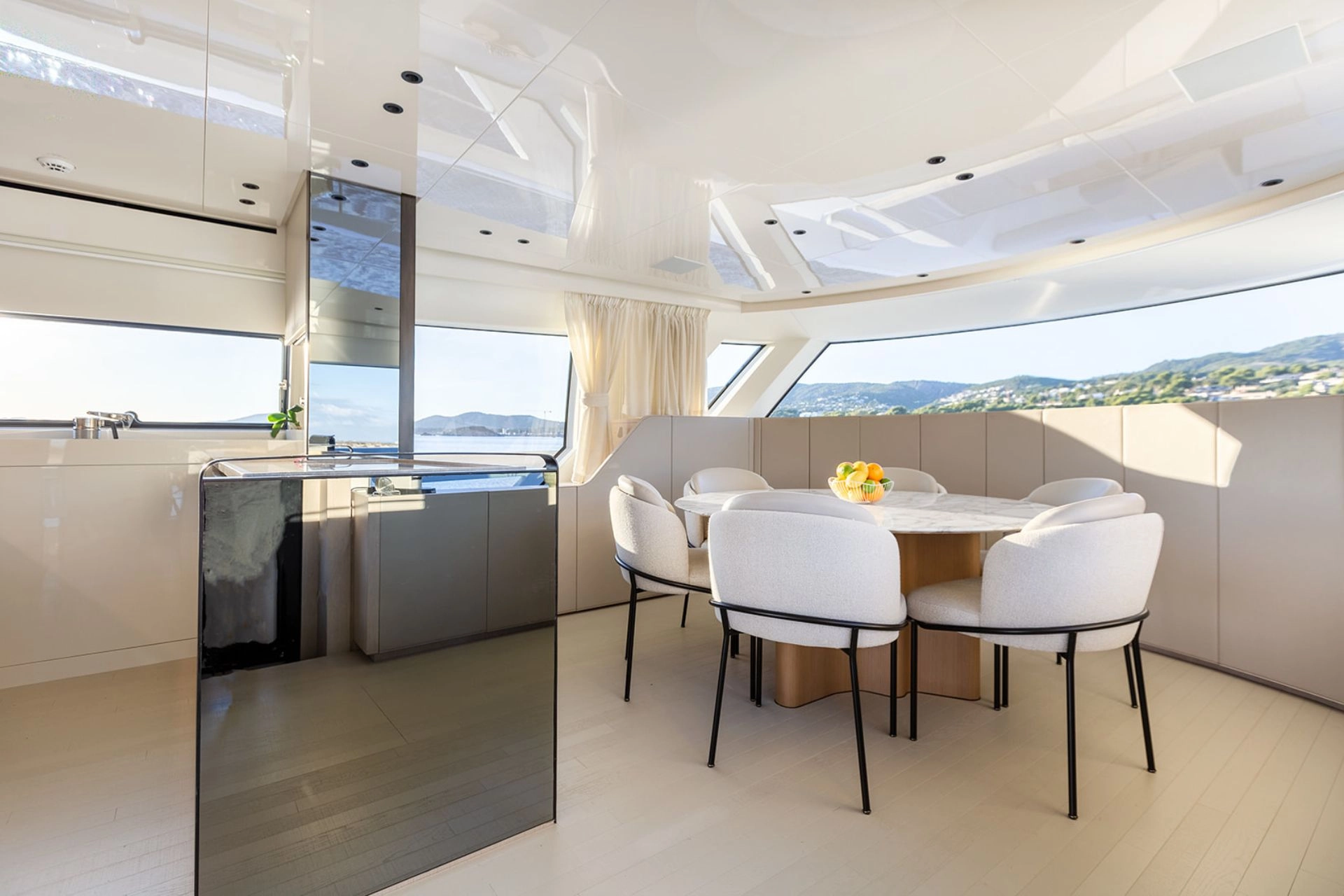 Dining area and galley of charter yacht Sanlorenzo SX76 Cloud IX in Mallorca.