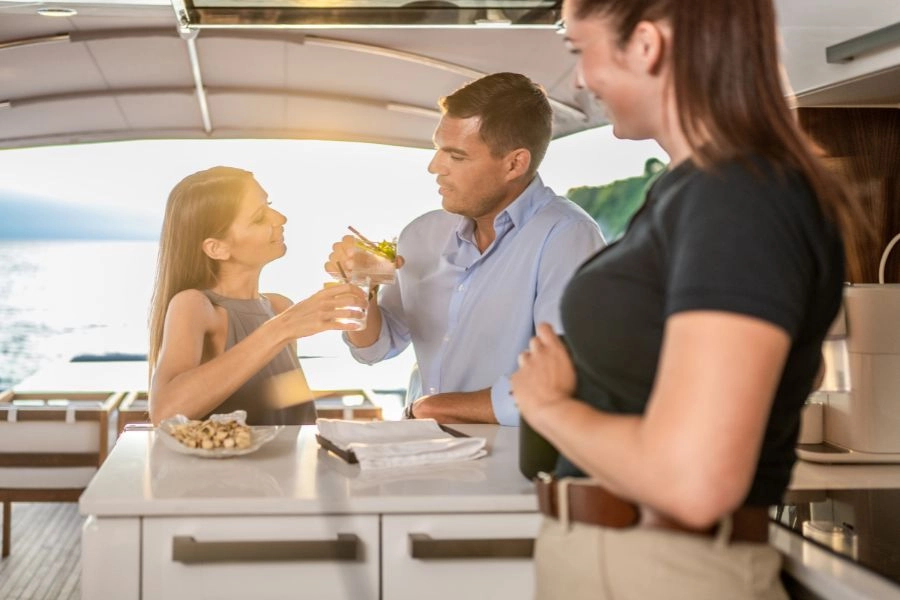 Yacht charter guests and stewardess on a boat.