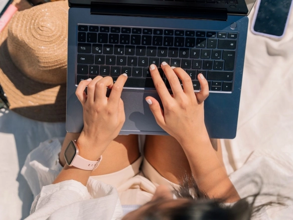Woman with laptop at the beach.