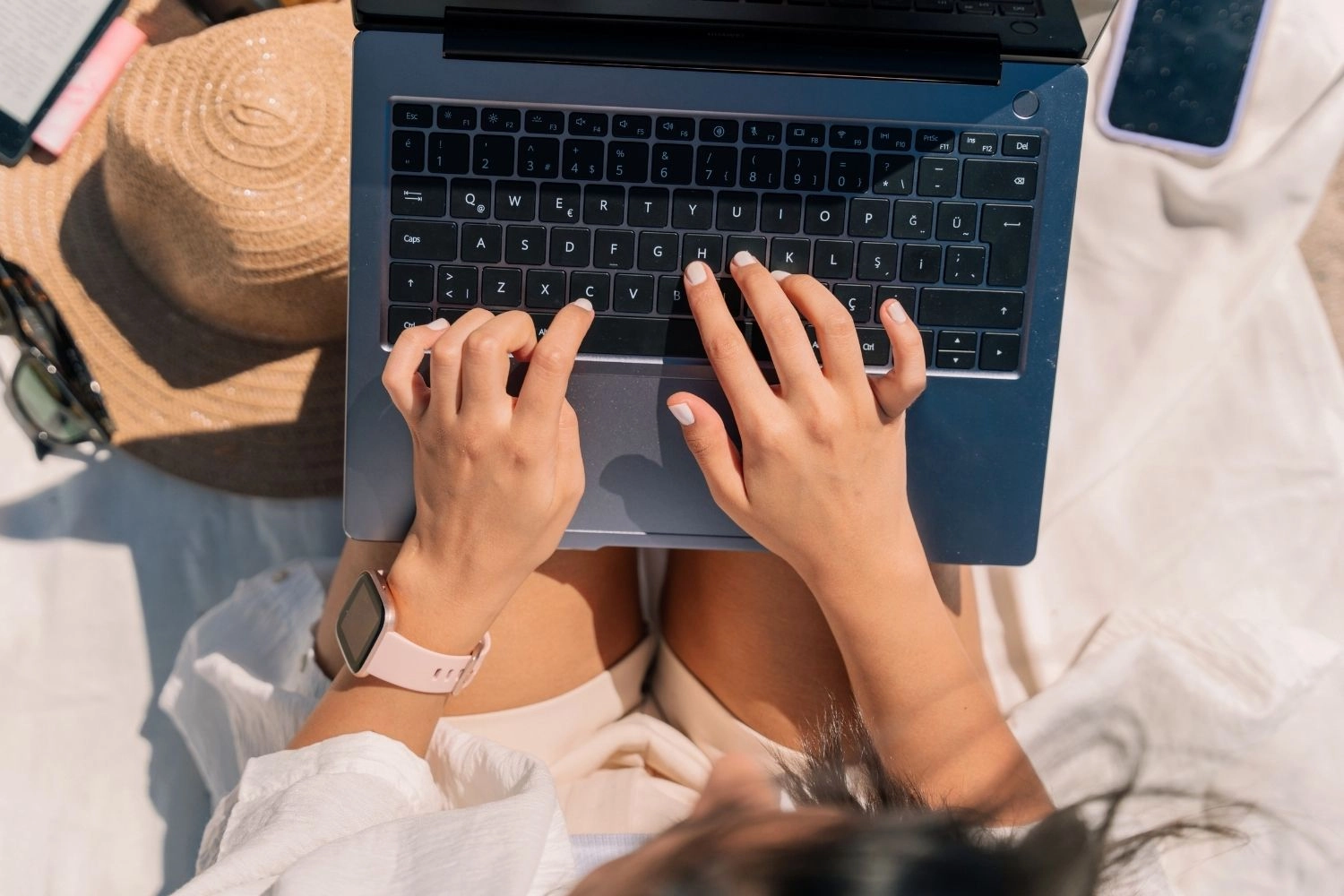 Woman with laptop at the beach.