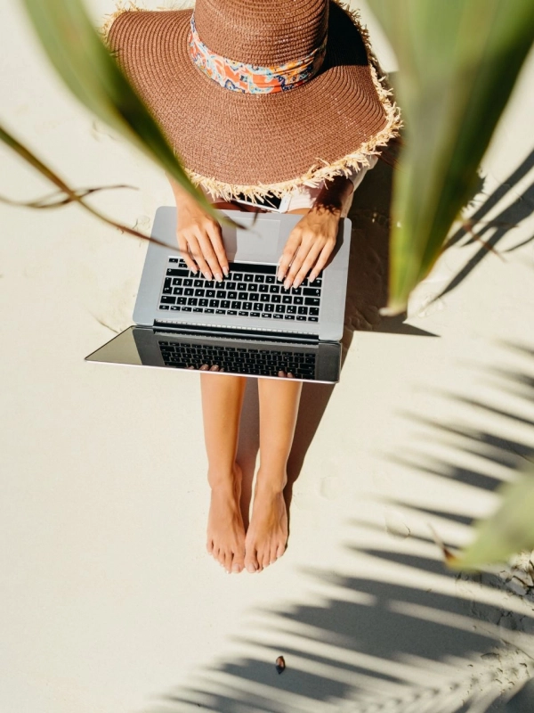 beach-laptop Woman at the beach with laptop and sunhat.