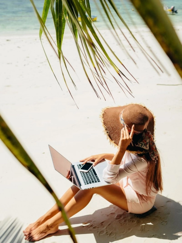 woman-beach-laptop Woman with laptop and phone on the beach.
