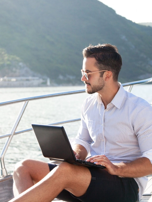 yacht-owner-contact Yacht owner with laptop on sailing yacht.